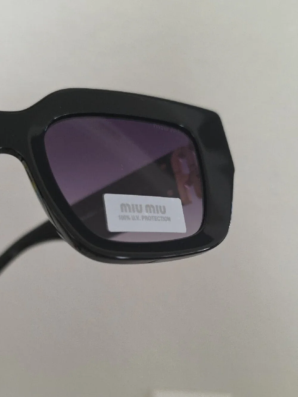 Miu Miu Glossy Black Frame Sunglasses with Purple Lenses